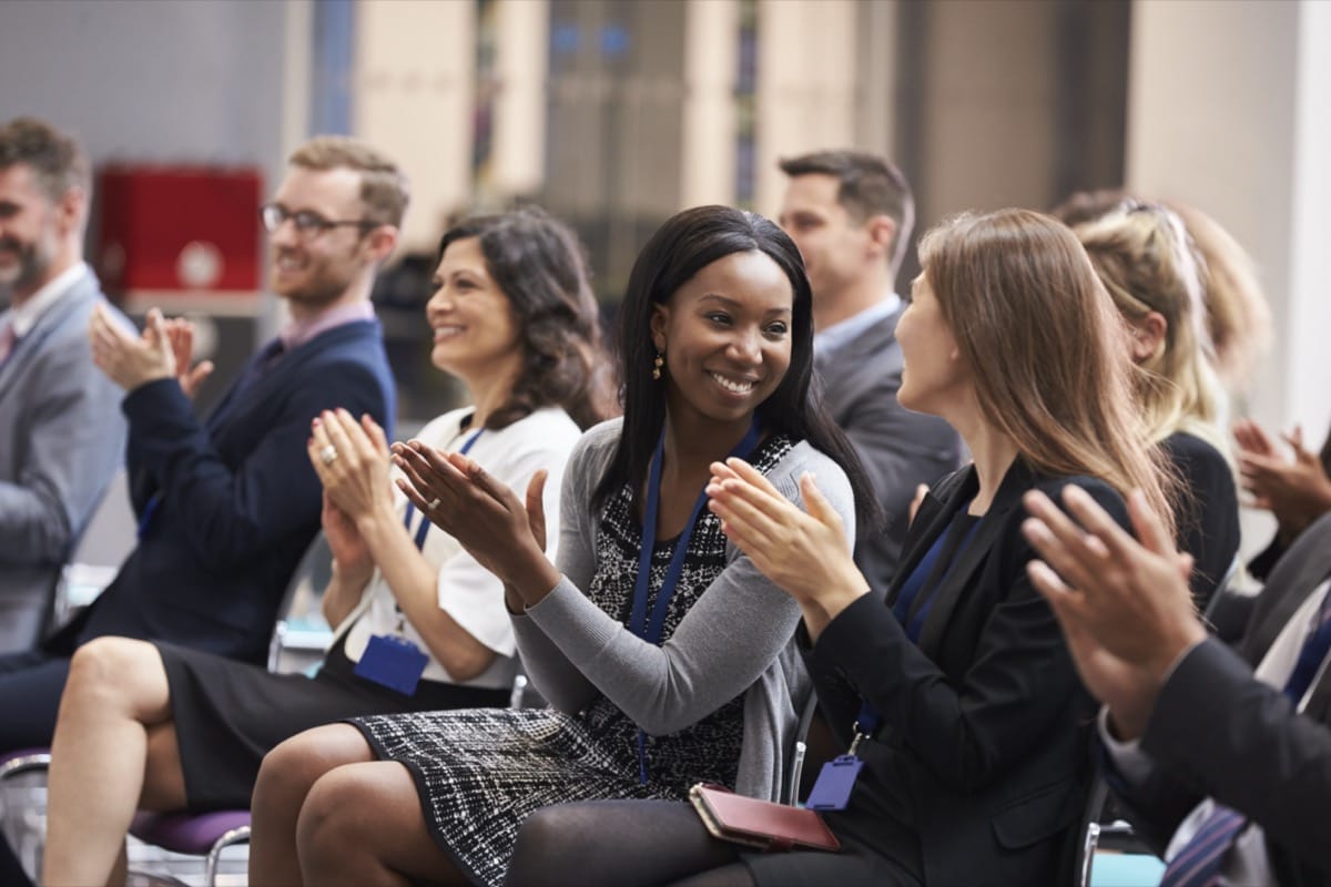 Audience applauding and smiling; PMSA Conference concept