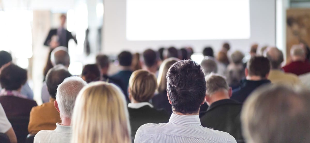 Speaker and audience in a conference hall; PMSA Conference concept