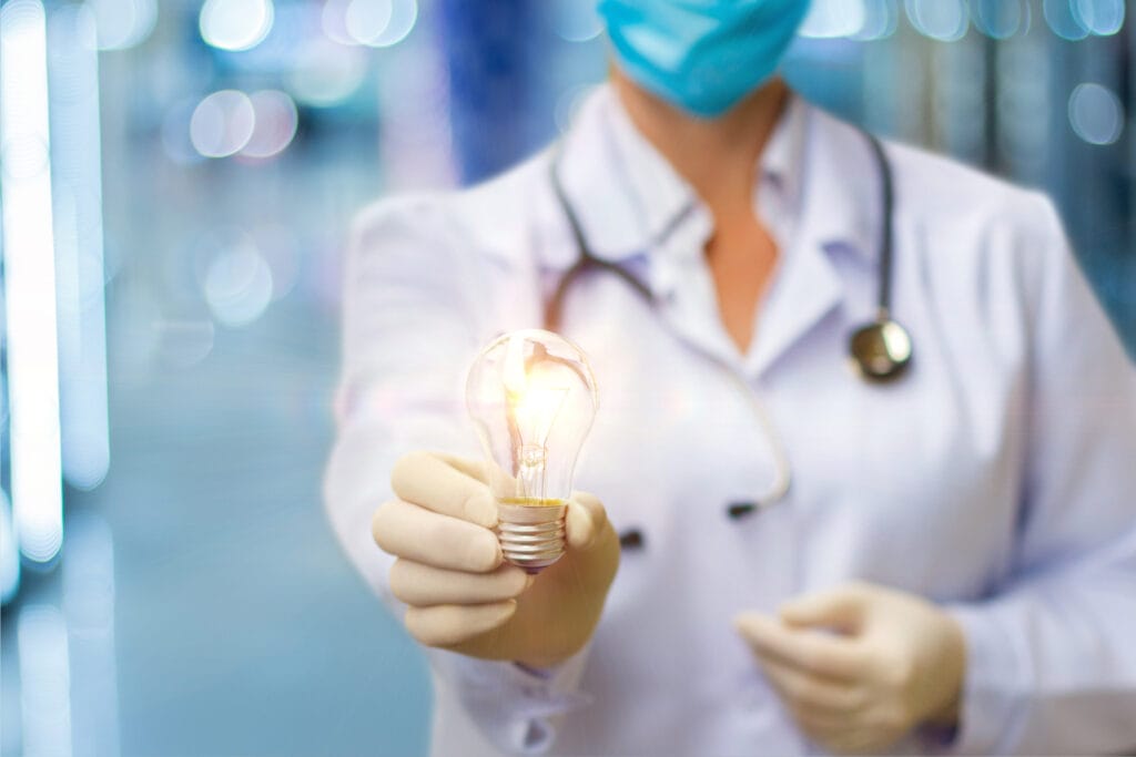 A doctor holds a glowing light bulb, symbolizing bright ideas and the promise of a healthier future.